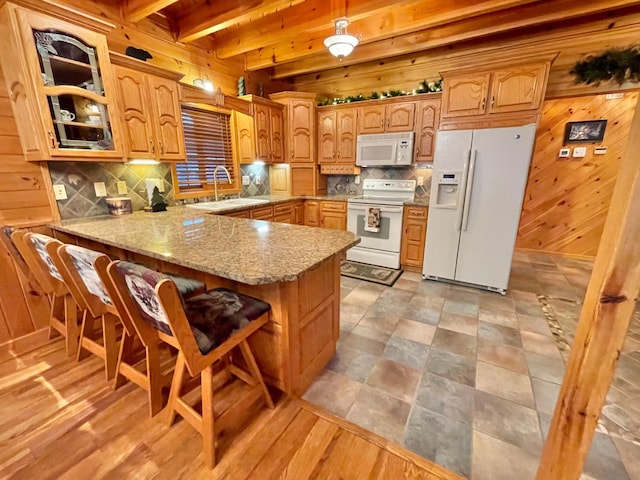 29724 387th St, Waubun, MN 56589 - kitchen with white appliances, a sink, wood walls, backsplash, and a peninsula