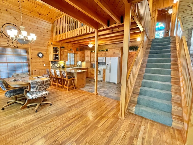 29724 387th St, Waubun, MN 56589 - dining space with wooden walls, stairway, a chandelier, light wood-style flooring, and beamed ceiling