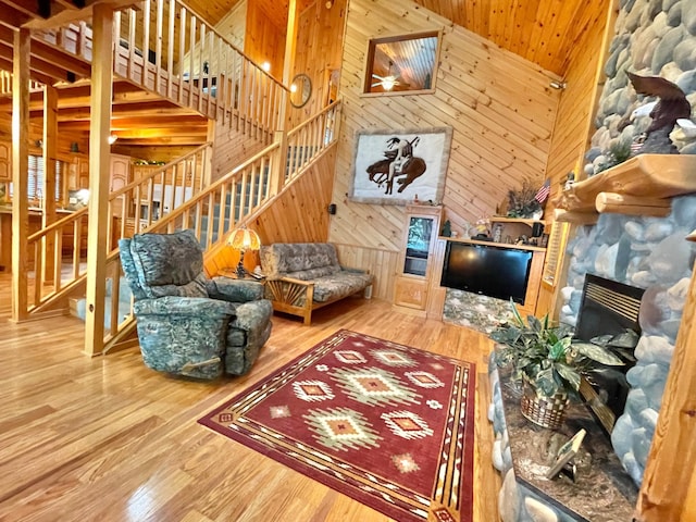 29724 387th St, Waubun, MN 56589 - living area with wooden walls, stairs, wood finished floors, and a stone fireplace