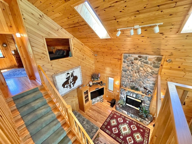 29724 387th St, Waubun, MN 56589 - living room featuring a skylight, wood finished floors, a stone fireplace, and wooden walls