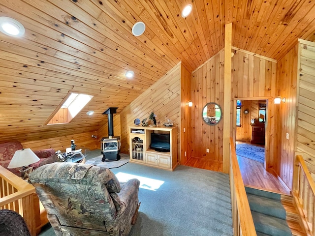 29724 387th St, Waubun, MN 56589 - carpeted living area featuring a wood stove, lofted ceiling, a skylight, wood walls, and wooden ceiling