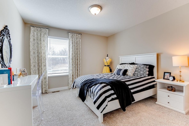 bedroom with light carpet and a textured ceiling