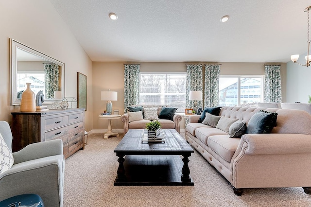 living room featuring light carpet, an inviting chandelier, lofted ceiling, and a healthy amount of sunlight