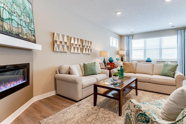 living room featuring a textured ceiling and light wood-type flooring