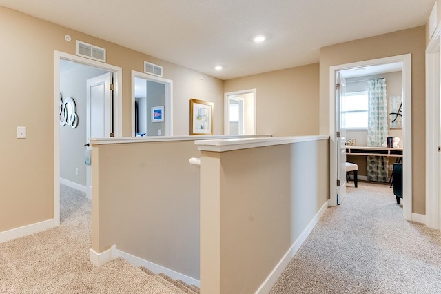 hallway with light colored carpet