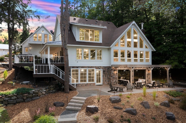 back house at dusk featuring an outdoor hangout area and a patio