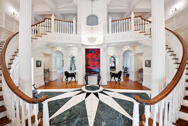 17950 Breezy Point Rd, Woodland, MN 55391 - foyer featuring stairway, a decorative wall, a high ceiling, decorative columns, and a chandelier