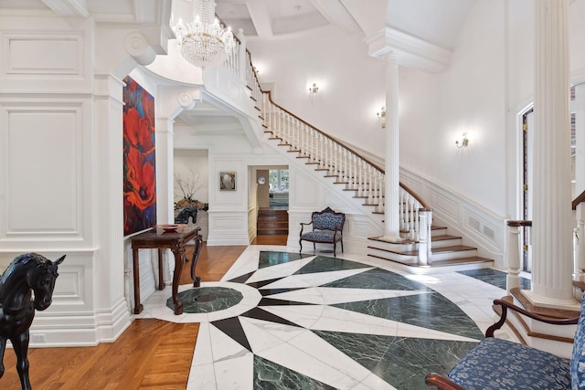 17950 Breezy Point Rd, Woodland, MN 55391 - foyer entrance featuring a decorative wall, a towering ceiling, ornate columns, stairs, and inlaid floor details
