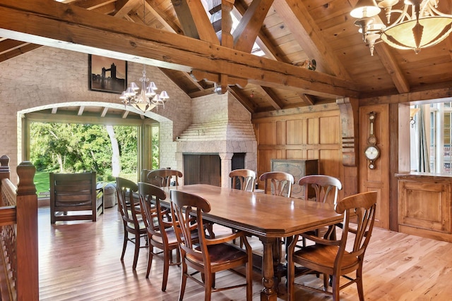 17950 Breezy Point Rd, Woodland, MN 55391 - dining room featuring high vaulted ceiling, hardwood / wood-style floors, a chandelier, wooden ceiling with exposed beams, and wood walls