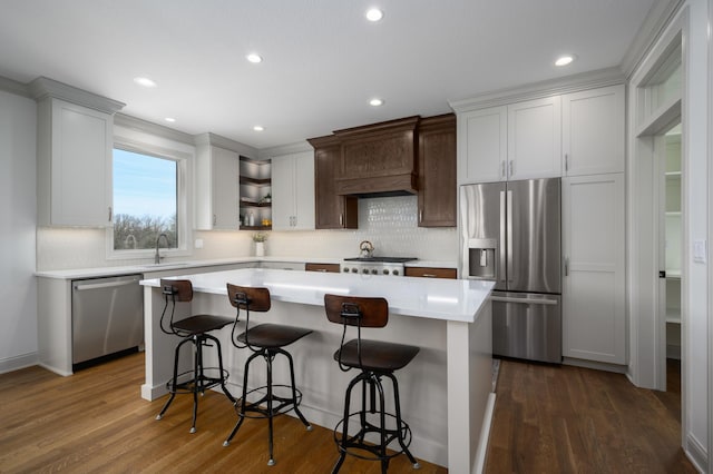 kitchen featuring a breakfast bar, premium range hood, stainless steel appliances, dark hardwood / wood-style floors, and a center island