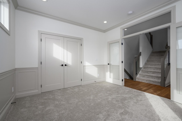 foyer entrance featuring ornamental molding and carpet flooring