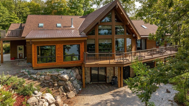 rear view of house featuring a deck and a patio area