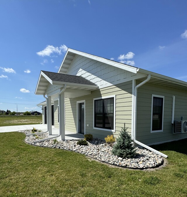 back of property featuring central AC unit and a lawn