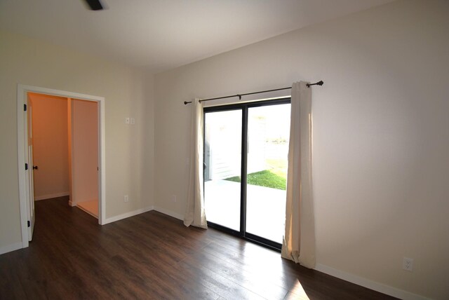 unfurnished room with dark wood-type flooring