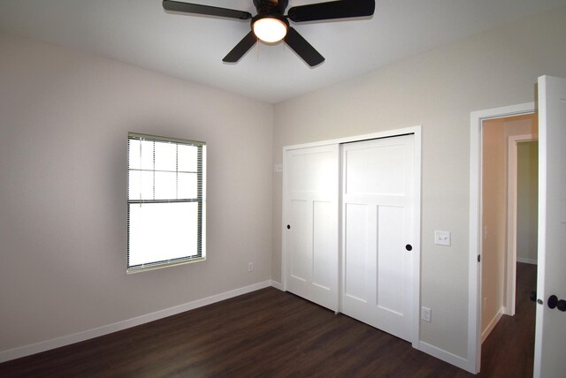 unfurnished bedroom with dark hardwood / wood-style flooring, a closet, and ceiling fan