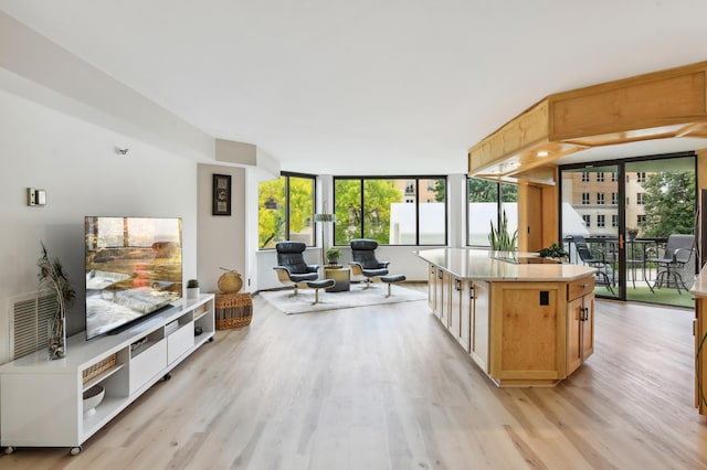 kitchen featuring light wood-style floors, open floor plan, light countertops, and a center island