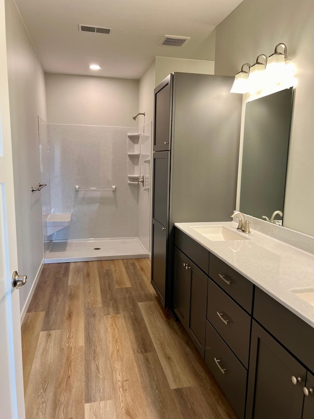 bathroom with vanity, a shower, and hardwood / wood-style flooring