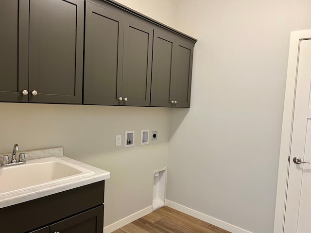 washroom with hookup for an electric dryer, sink, hardwood / wood-style flooring, washer hookup, and cabinets