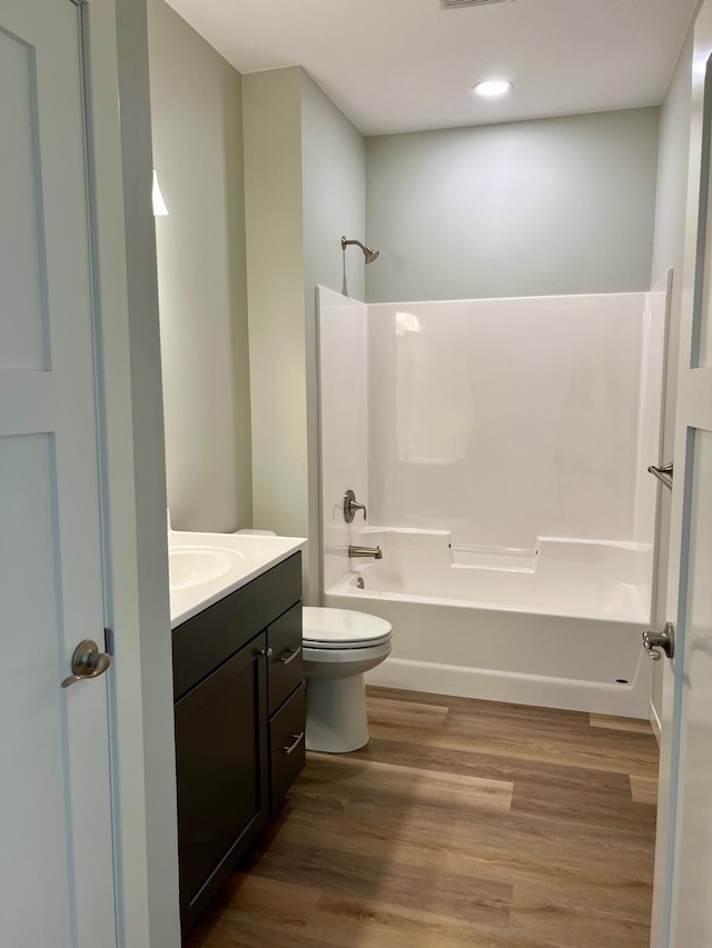 full bathroom featuring vanity, toilet, hardwood / wood-style flooring, and  shower combination