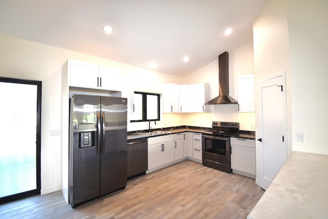 kitchen featuring sink, wall chimney range hood, white cabinetry, appliances with stainless steel finishes, and light wood-type flooring