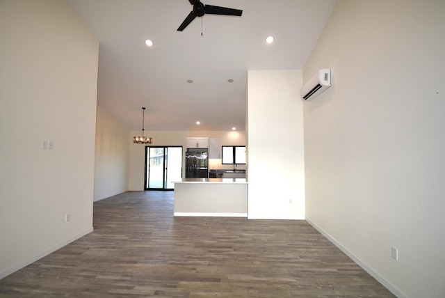 unfurnished living room featuring ceiling fan with notable chandelier, dark hardwood / wood-style flooring, and a wall unit AC