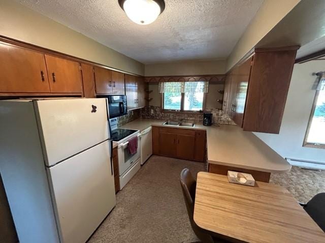 306 9th St, Westbrook, MN 56183 - kitchen with white appliances, a textured ceiling, a baseboard radiator, light countertops, and brown cabinetry