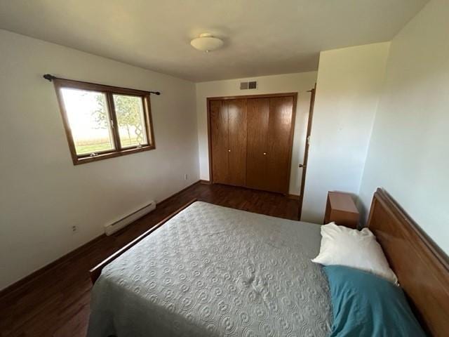 bedroom featuring dark hardwood / wood-style flooring, a closet, and a baseboard radiator