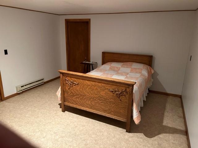 bedroom featuring a baseboard heating unit and carpet