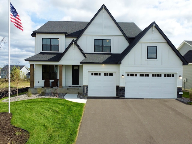 modern farmhouse featuring a front lawn, central AC unit, and a garage