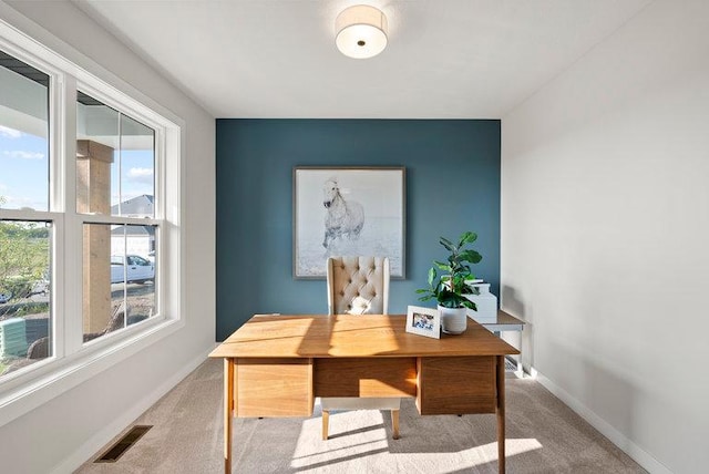 carpeted office space with baseboards and visible vents