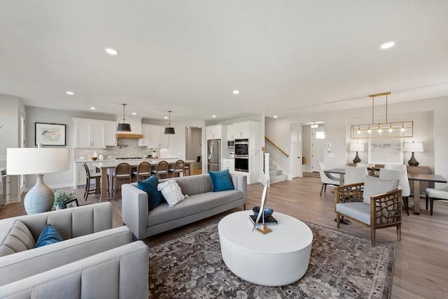 living room with stairs, recessed lighting, baseboards, and wood finished floors