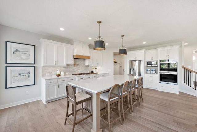 kitchen with premium range hood, appliances with stainless steel finishes, and white cabinets