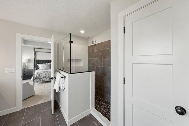 ensuite bathroom featuring ensuite bathroom, a textured ceiling, walk in shower, baseboards, and tile patterned floors