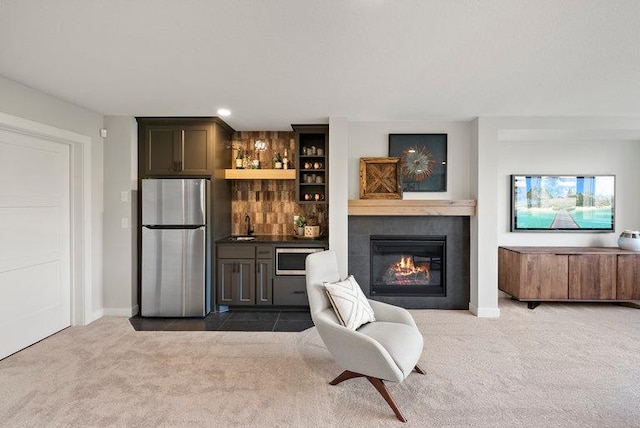 interior space with baseboards, a fireplace, dark carpet, and indoor wet bar