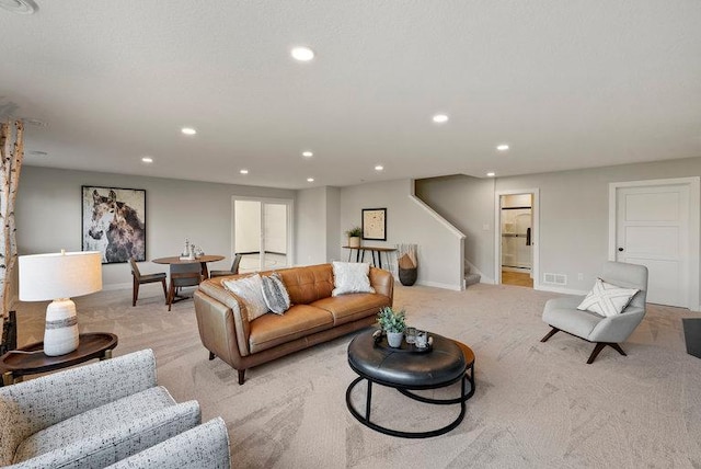 living area with light carpet, visible vents, stairway, and recessed lighting