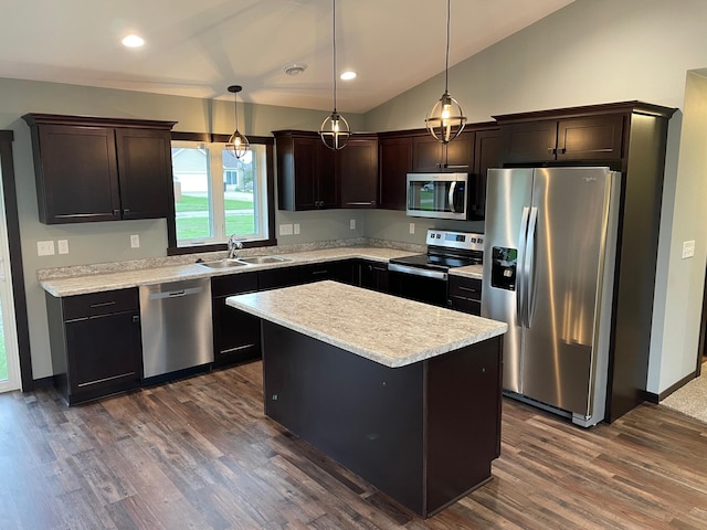 kitchen featuring a center island, vaulted ceiling, hanging light fixtures, stainless steel appliances, and dark brown cabinetry