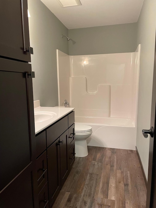 full bathroom with shower / tub combination, vanity, hardwood / wood-style floors, and toilet