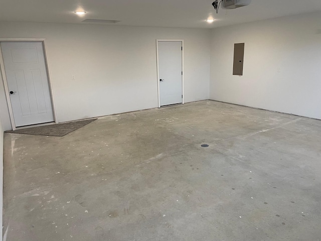 garage with a garage door opener and electric panel