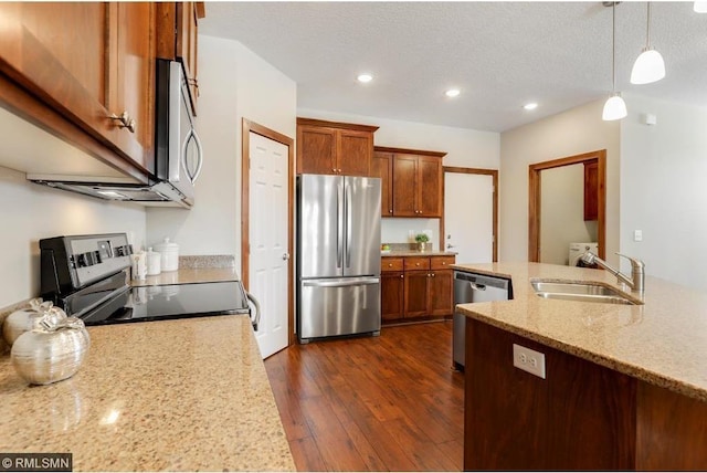 kitchen featuring appliances with stainless steel finishes, pendant lighting, dark wood-type flooring, a textured ceiling, and sink