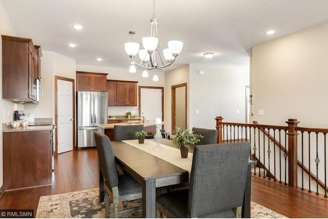 dining room featuring an inviting chandelier, dark hardwood / wood-style floors, and sink