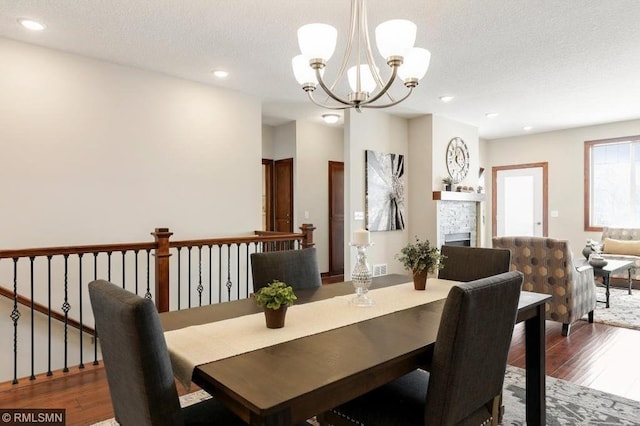 dining area featuring dark hardwood / wood-style floors, an inviting chandelier, and a textured ceiling