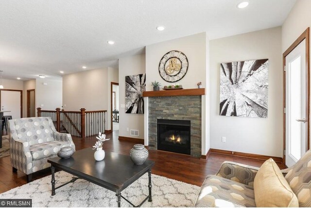 living room featuring dark hardwood / wood-style flooring, a fireplace, and a healthy amount of sunlight