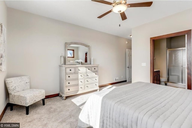 bedroom with ceiling fan, light colored carpet, and ensuite bathroom