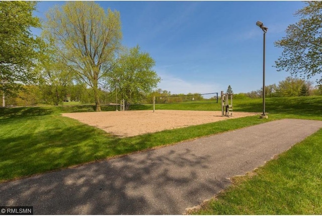 view of property's community with volleyball court and a yard