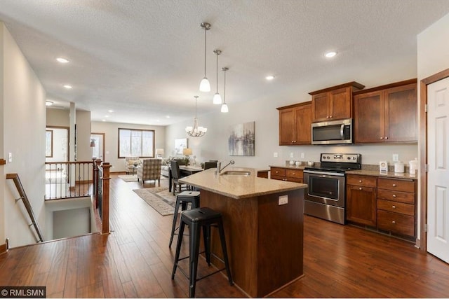 kitchen featuring an inviting chandelier, dark hardwood / wood-style floors, stainless steel appliances, sink, and hanging light fixtures