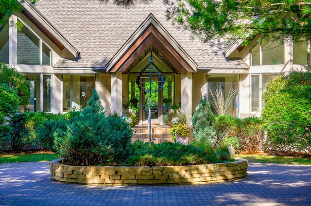 1 Capaul Woods Ct, North Oaks, MN 55127 - entrance to property featuring roof with shingles and stucco siding