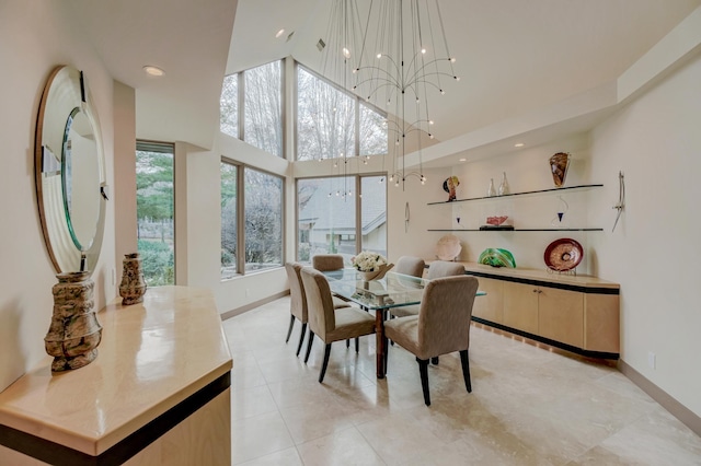 dining room with a towering ceiling and an inviting chandelier