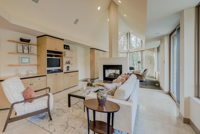 living room with a multi sided fireplace and a high ceiling