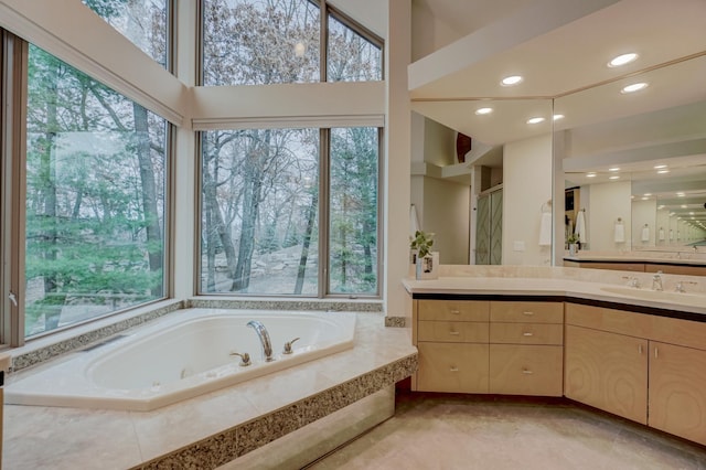 bathroom featuring plus walk in shower, plenty of natural light, and vanity