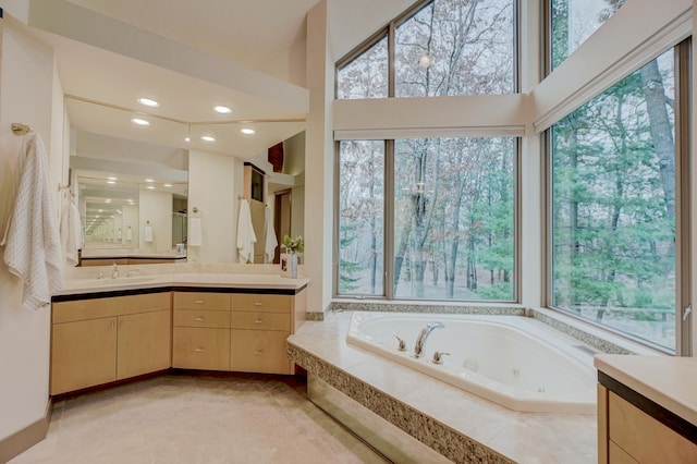 bathroom featuring tiled bath and vanity